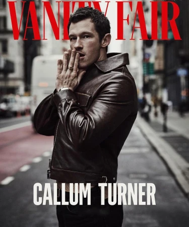 Callum Turner wearing a dark brown leather jacket on a city street, photographed by Matthew Brookes for Vanity Fair magazine cover.