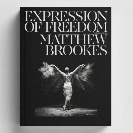 Book cover featuring a black and white image of a dancer surrounded by powder, with white serif typography reading Expression of Freedom by Matthew Brookes