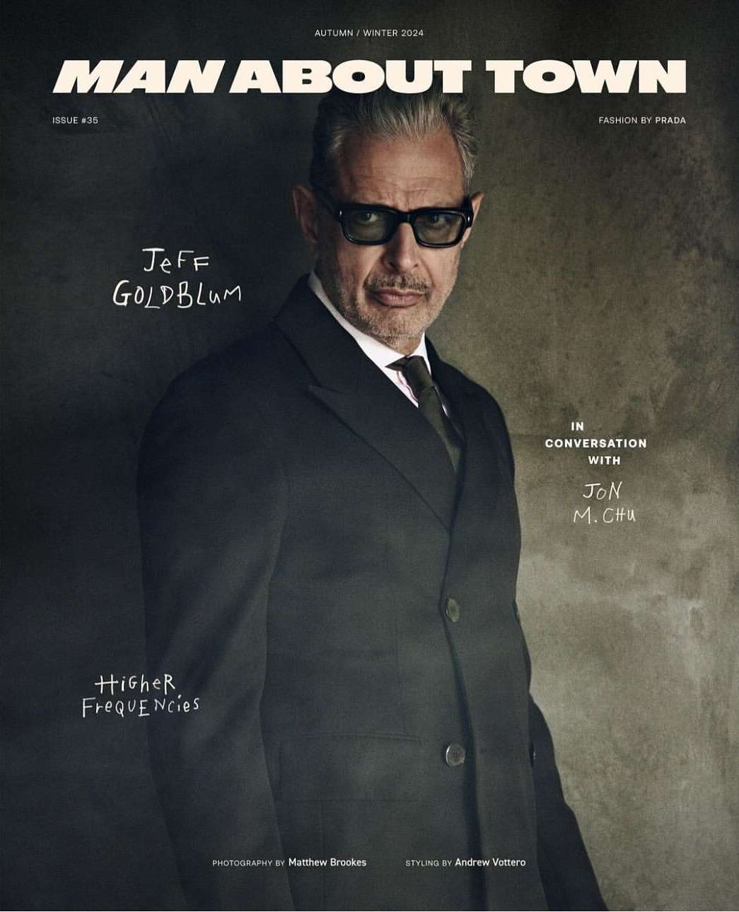 Man About Town magazine cover featuring Jeff Goldblum in a suit and tie, shot in a photo studio with soft lighting and a neutral background.