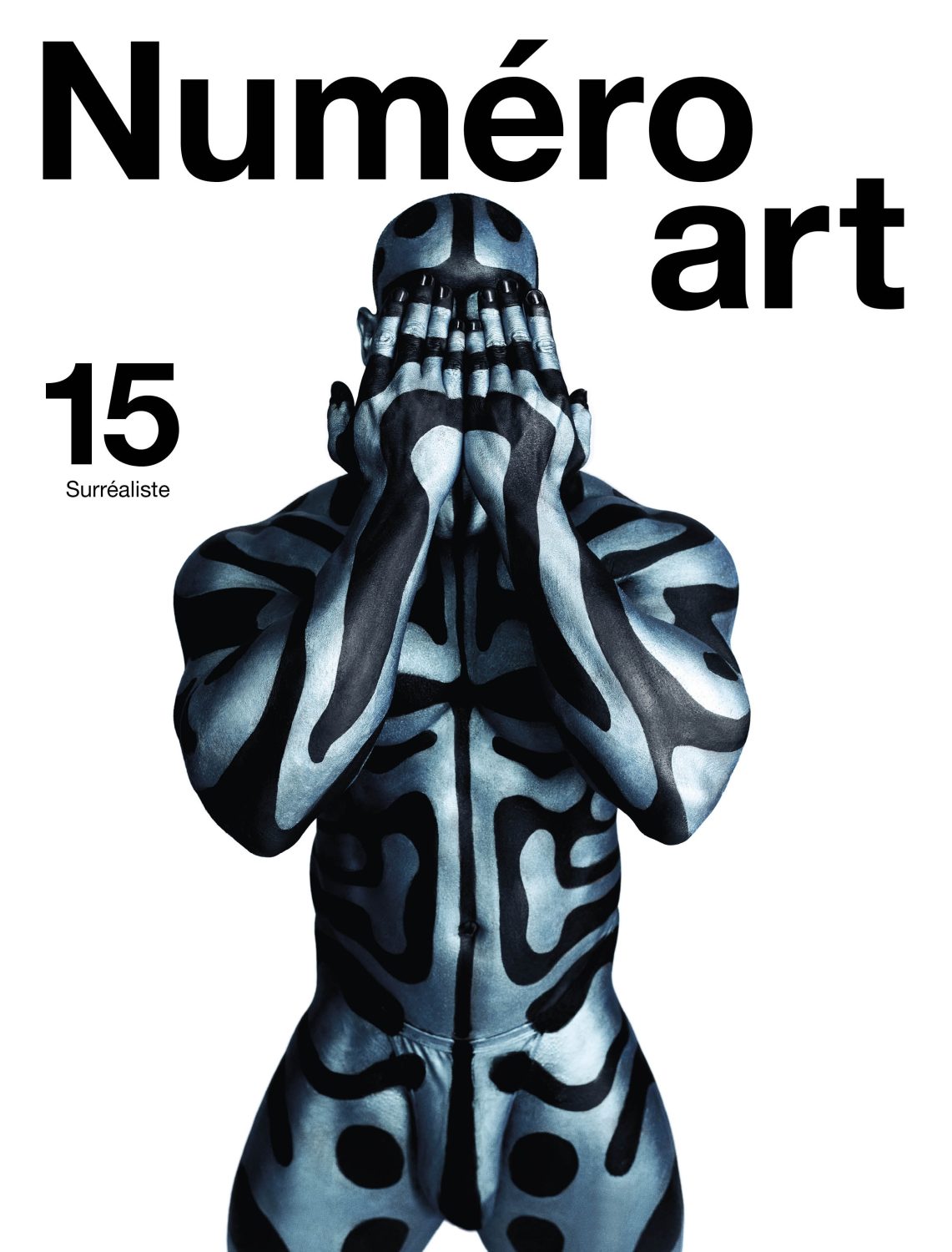 Magazine cover features a body painted adult with abstract design, hands covering face, and bold typographic elements against white backdrop.