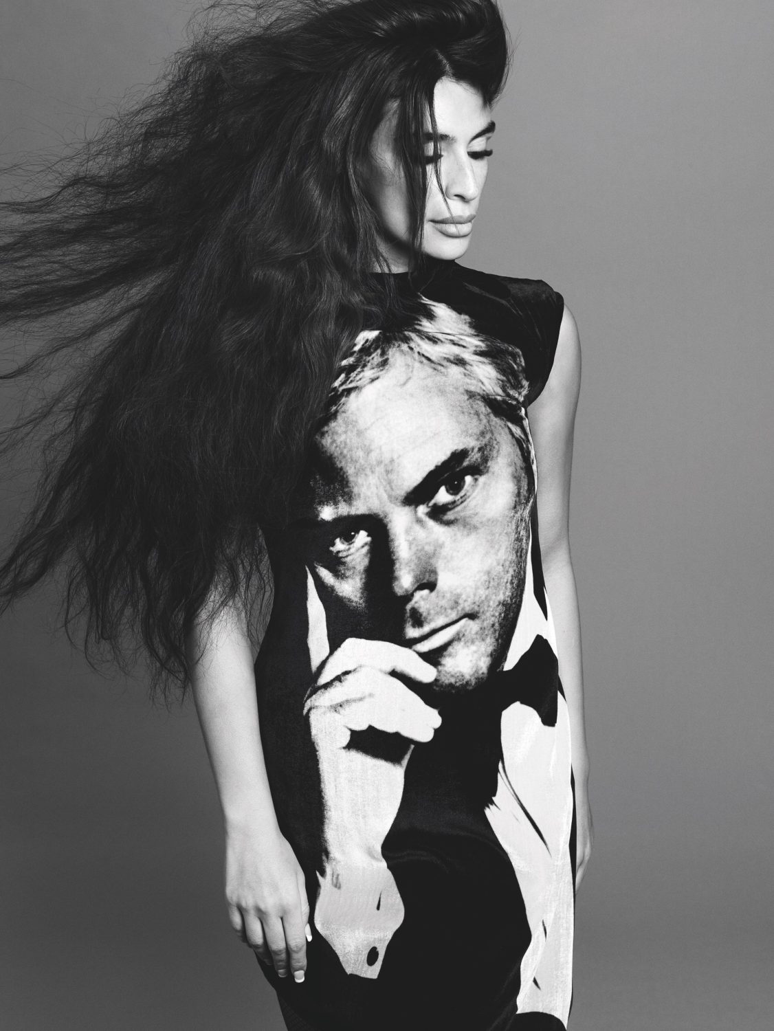 Black and white portrait of a woman with long voluminous hair wearing a graphic print dress by casting director Maxime Valentini