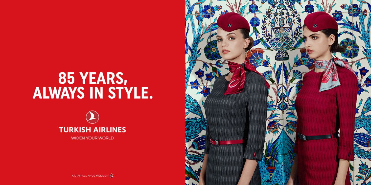 Two women in airline uniforms stand against a patterned tile backdrop for Turkish Airlines, with red promotional text on the left.