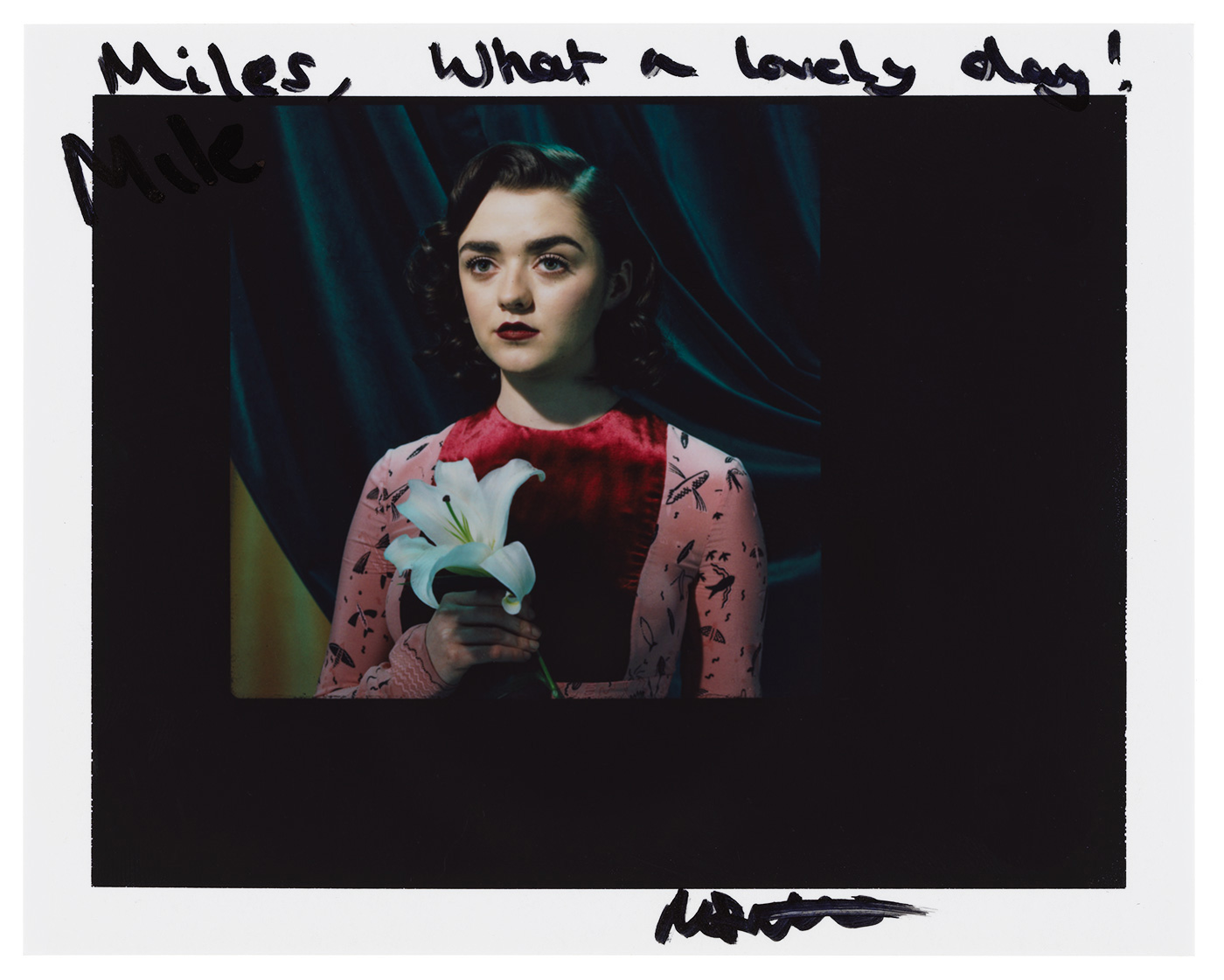 Glamorous portrait of a young woman with red lips, holding a white lily in front of a dark teal and yellow backdrop with handwritten text.