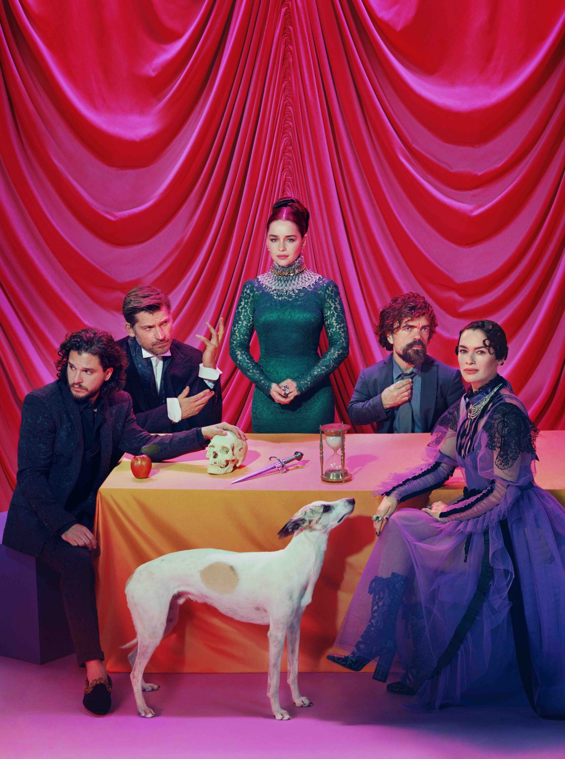 Group of people and dog pose in front of a red-draped table. People wear formal attire. On the table are props and an hourglass.