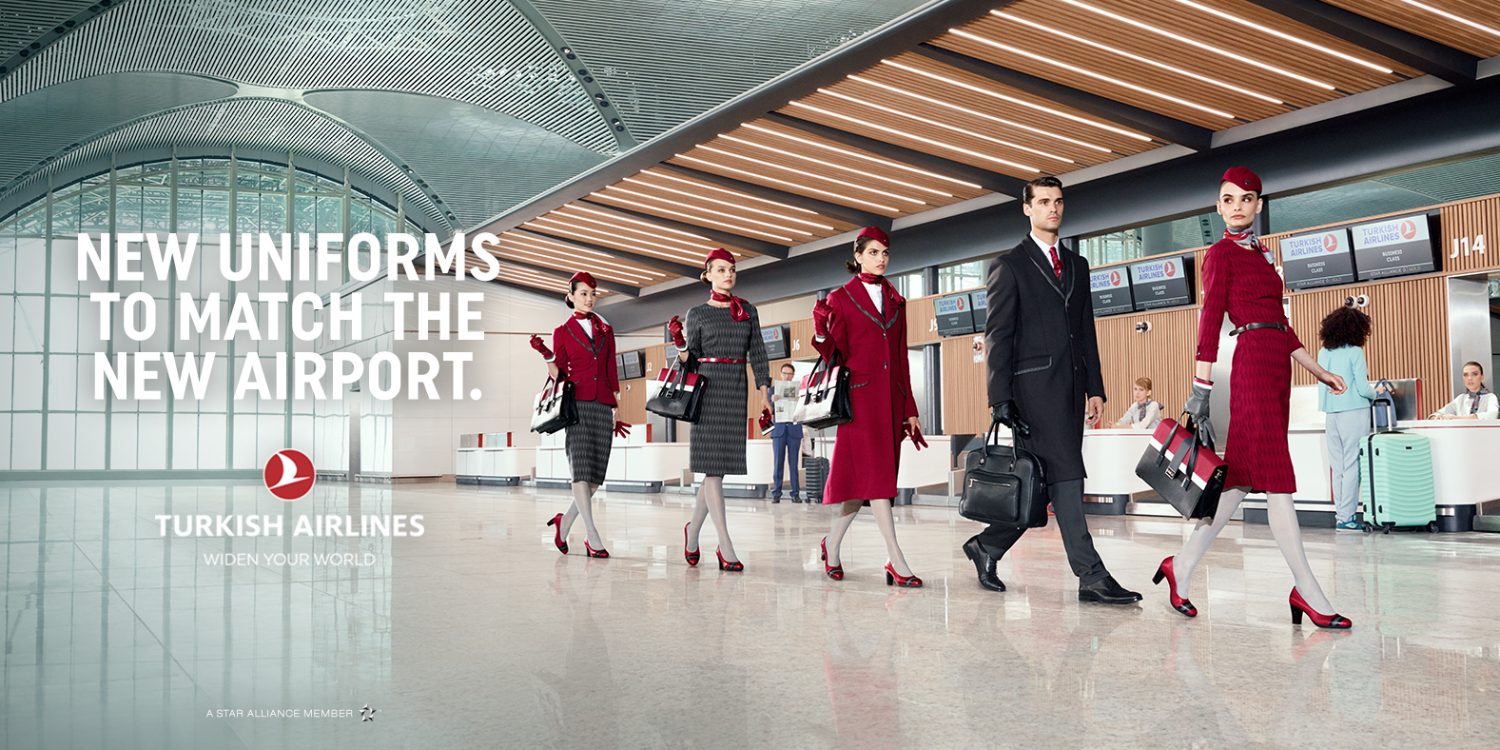 Turkish Airlines ad featuring airline staff in new uniforms walking through an airport terminal with modern architecture and lighting.