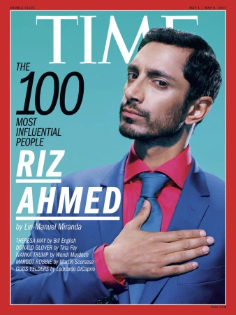 Time Magazine cover featuring Riz Ahmed in a blue suit and pink shirt against a light blue backdrop with red border.