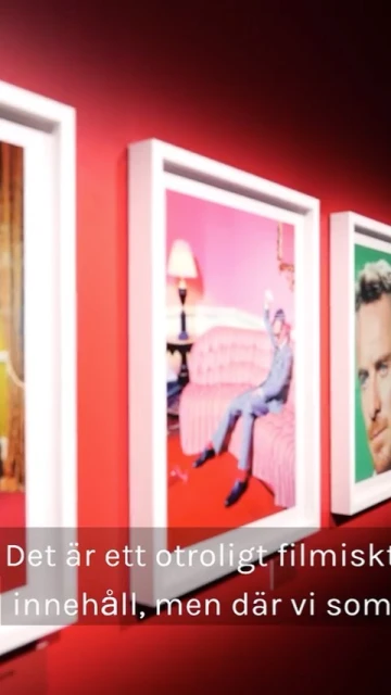 Three framed photographs hang on a red wall, displaying a man in a pink room, a portrait, and a warm-toned image.