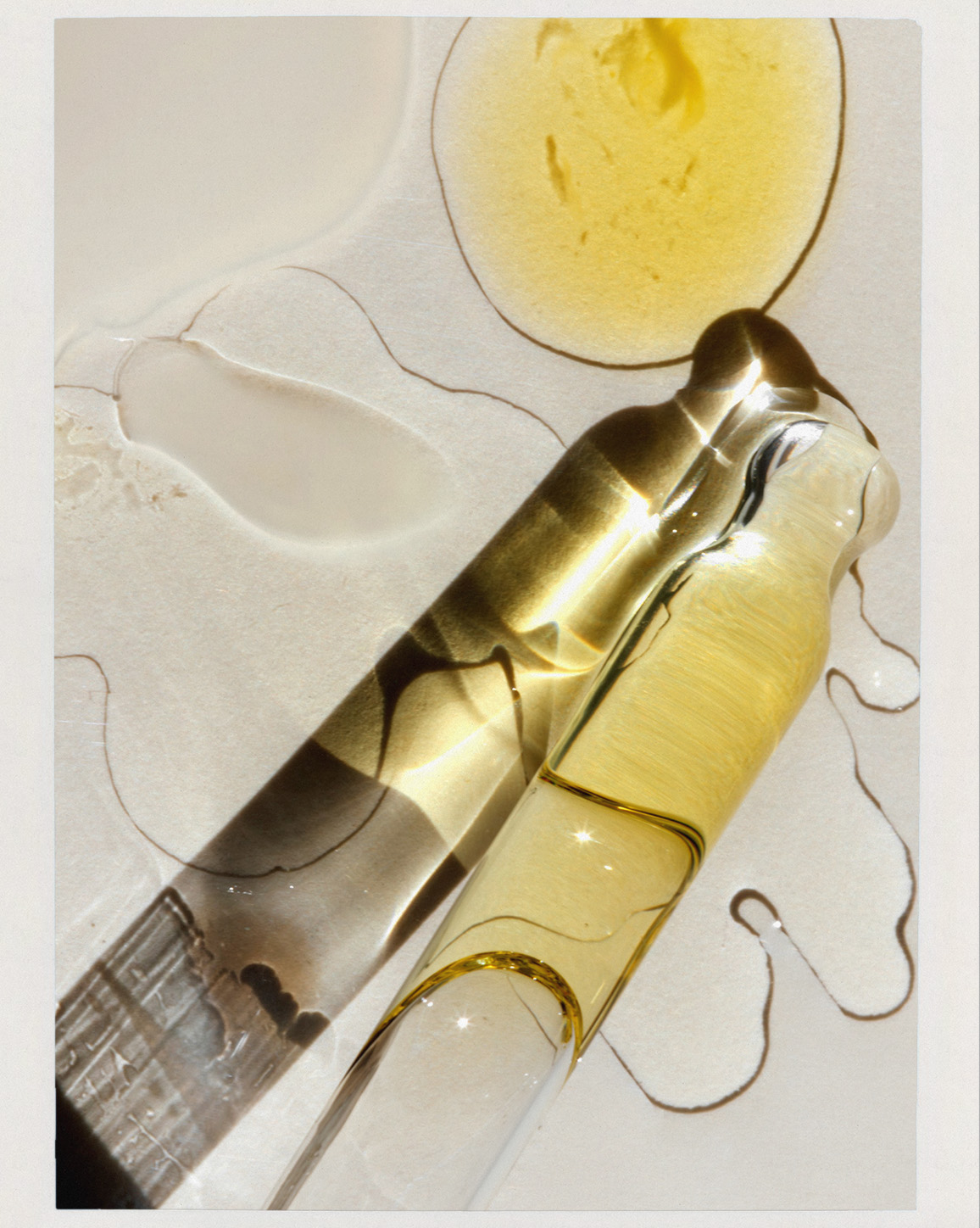 Close-up showcasing skincare product with clear glass dropper against a neutral backdrop, highlighting the serum's texture and consistency.