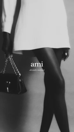 Monochrome fashion image of a model wearing a short white dress and black tights holding a handbag by Stephen Kidd