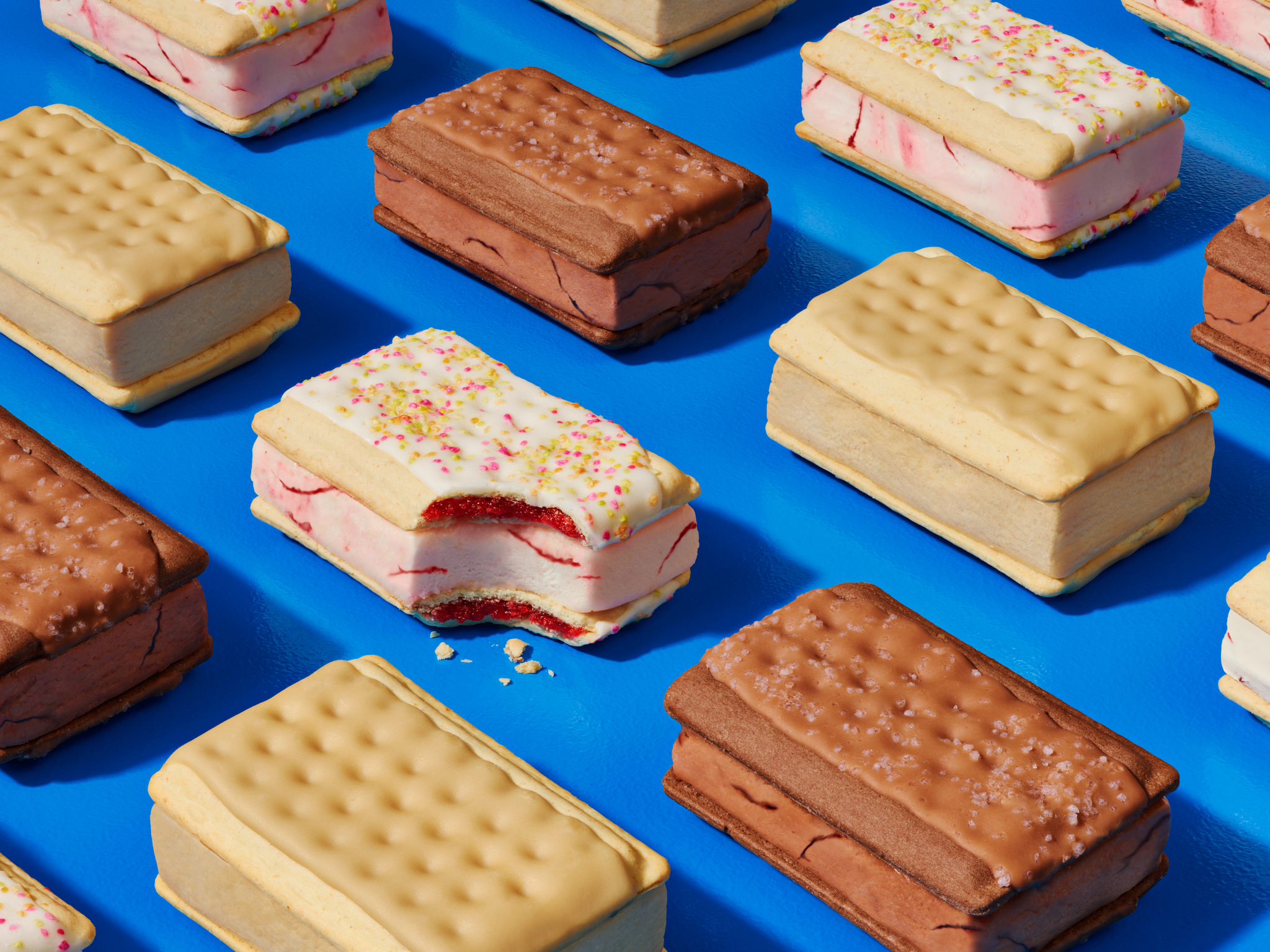 Arrangement of ice cream sandwiches with vanilla, chocolate, and strawberry flavors on a blue background with a studio lighting.
