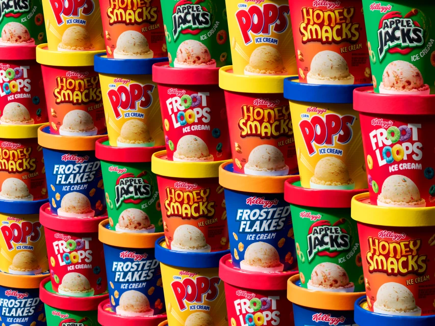Colorful wall of Kellogg's cereal-flavored ice cream tubs stacked high, featuring brands like Apple Jacks, Honey Smacks, Frosted Flakes, Froot Loops, and Pops.