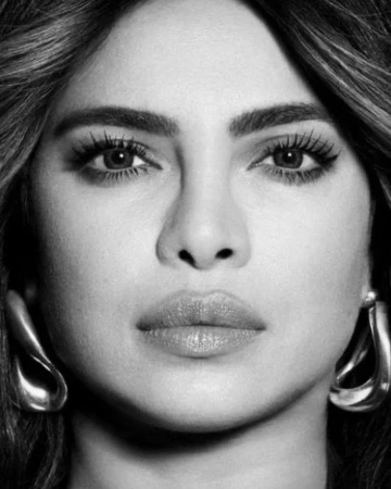 Close-up monochrome portrait of Priyanka Chopra wearing sculptural metallic earrings