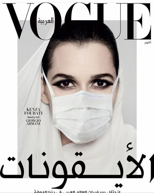 Vogue Arabia magazine cover featuring a woman wearing a hijab and a surgical mask, shot in a photo studio with dramatic lighting.