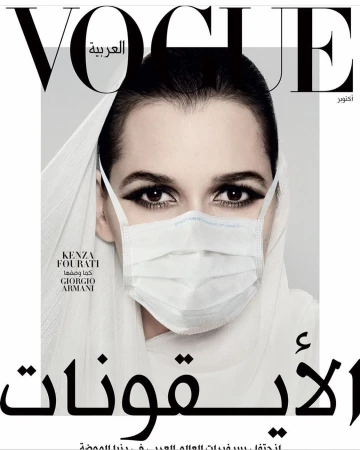 Vogue Arabia magazine cover featuring a woman wearing a hijab and a surgical mask, shot in a photo studio with dramatic lighting.