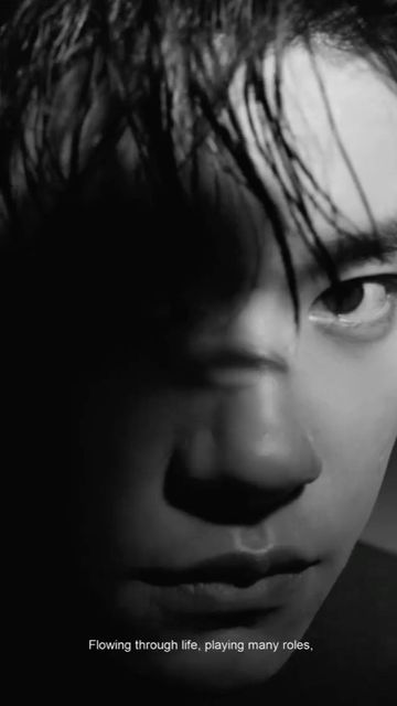 Close-up monochrome portrait of a man with wet hair and dramatic high-contrast lighting casting deep shadows across his face.