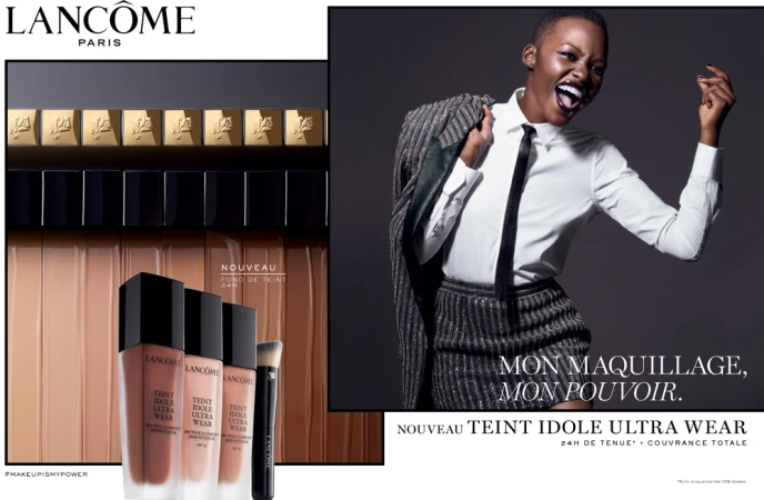 Cosmetic ad featuring a Black woman in a suit alongside Lancôme Teint Idole Ultra Wear foundation and makeup brush products.