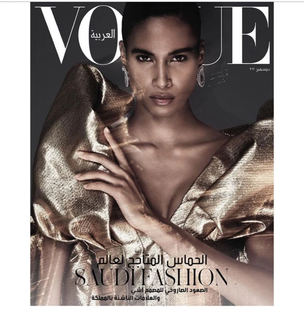 Vogue Arabia cover featuring a Black adult female model with gold eye shadow, wearing a shiny gold dress and diamond earrings in a studio.