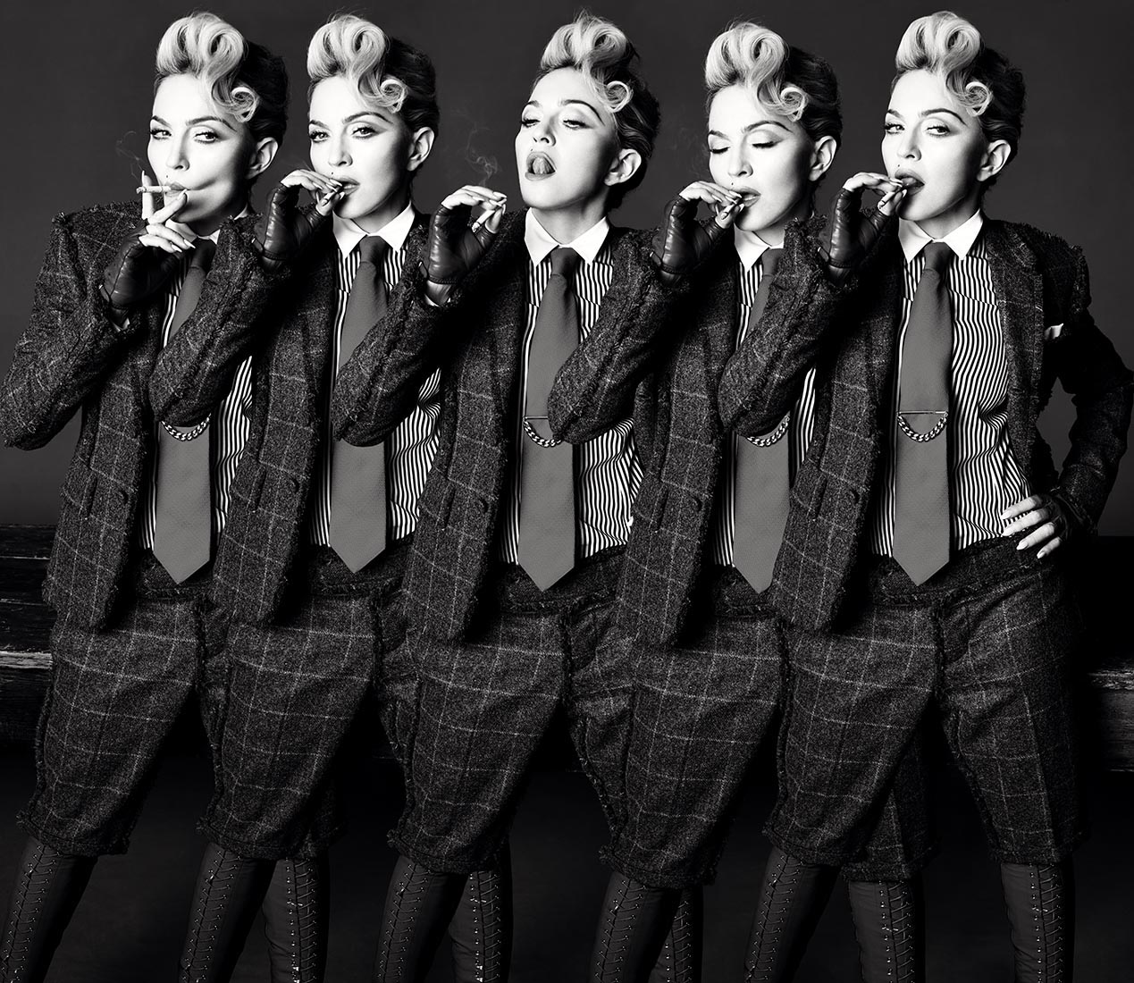 Black and white fashion shot of five instances of the same adult woman smoking a cigarette in a plaid suit with a tie and dress shoes.