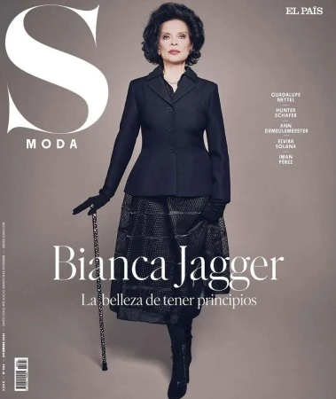 Bianca Jagger on El Pais S Moda magazine cover, wearing a dark jacket, patterned skirt, gloves, holding a cane, dark hair.