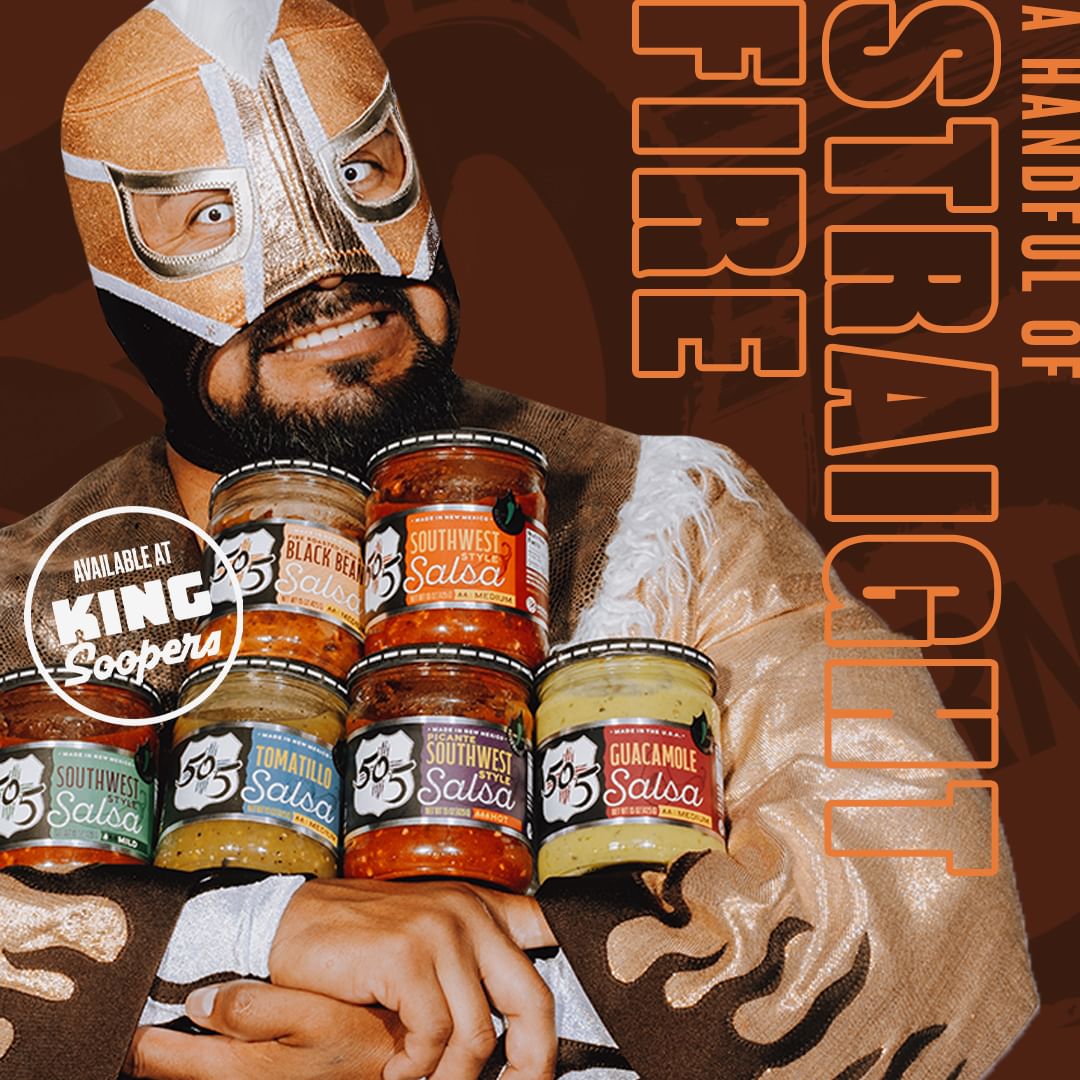 Professional wrestler in gold mask holds several jars of salsa; jars include "Southwest Salsa," with brand name available at King Soopers.