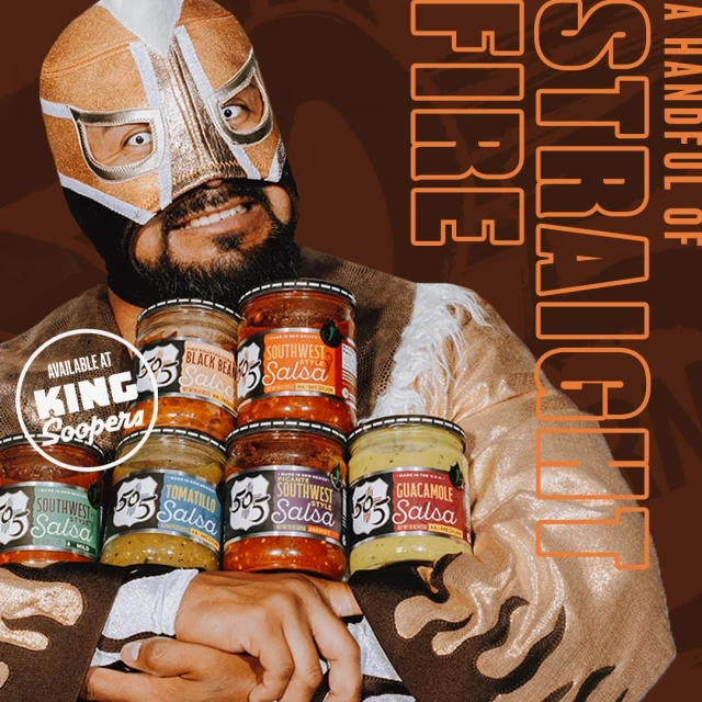 Professional wrestler in gold mask holds several jars of salsa; jars include "Southwest Salsa," with brand name available at King Soopers.