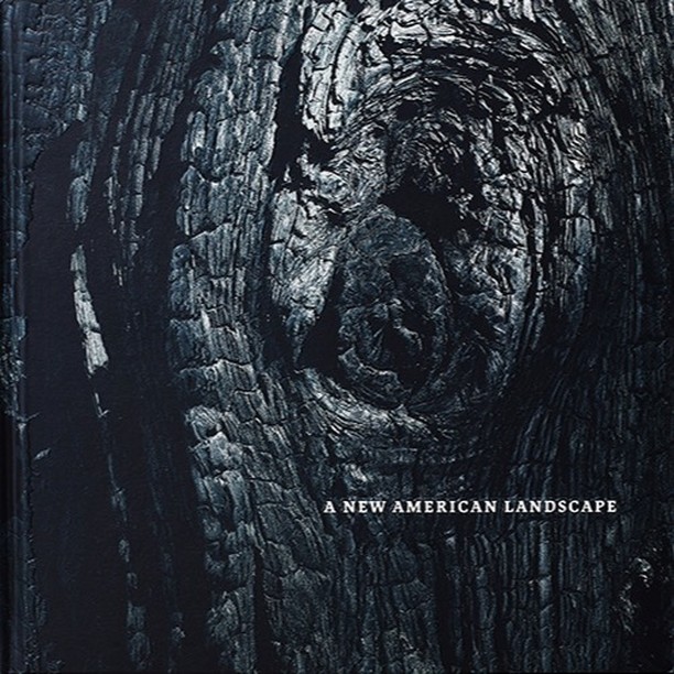 Monochromatic close-up shows a tree trunk's charred, textured bark with a knot, and the title 'A New American Landscape' at the bottom.