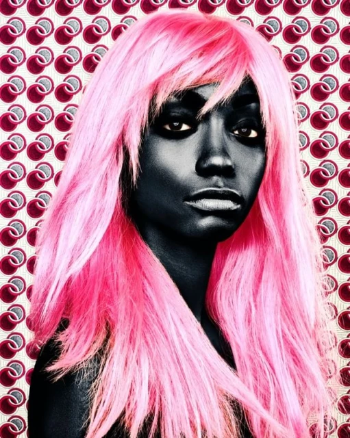 Close-up portrait of a woman with dark skin and pink hair against a pattern background, showcasing beauty and unique style.