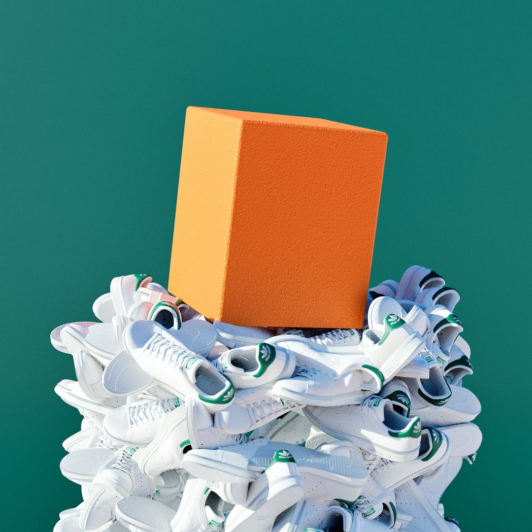 Pile of white Adidas Stan Smith sneakers with green accents topped by a vibrant orange cube against a solid teal backdrop.