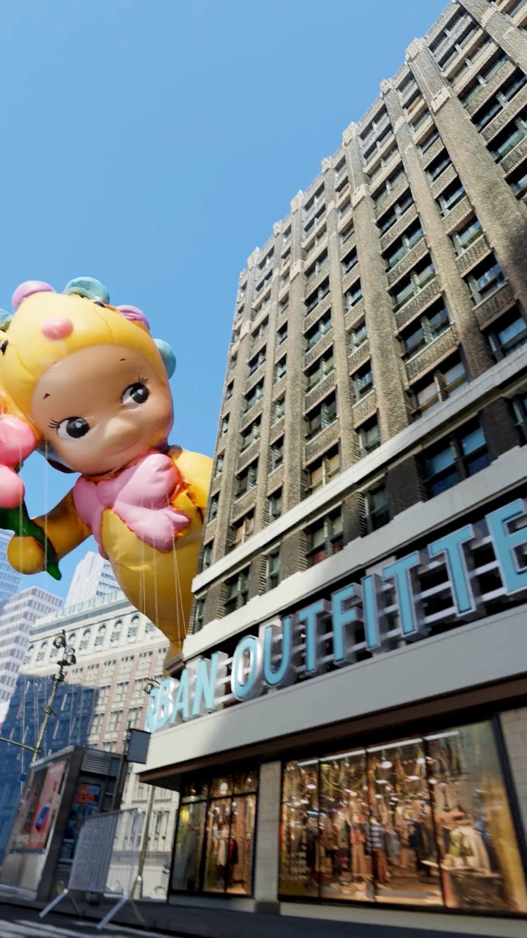 Low-angle shot of a parade balloon in the shape of a cartoon character in front of a building on a sunny day in a city.