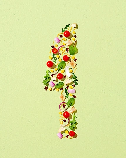 Number one made of salad ingredients on a green background. Food art with tomatoes, onion, cheese, lettuce, pasta and corn.