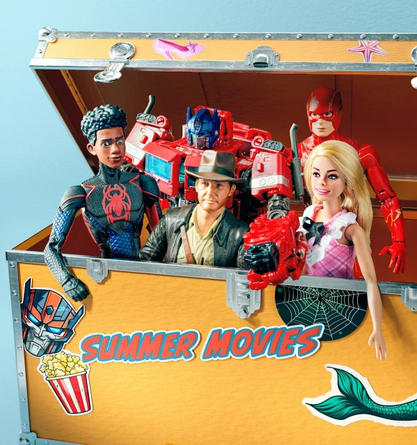 Collection of action figures including Spider-Man, Indiana Jones, Transformer, Flash, and Barbie inside of a toy box.