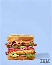 Stacked chicken sandwich on toasted bread, featuring lettuce, tomato, red onion, bacon, and pink sauce, against a light blue backdrop.