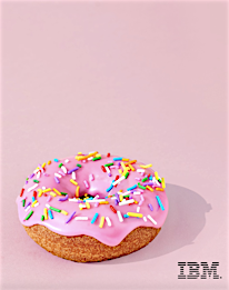 Overhead shot of a pink frosted doughnut with colorful sprinkles on a light pink background with shadow and the IBM logo at the bottom.