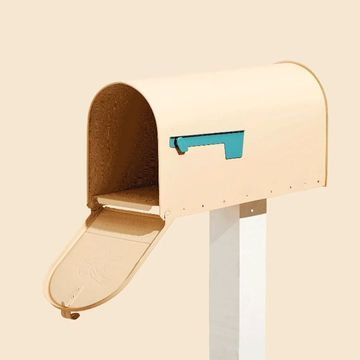 Beige mailbox with the door open on a white post, shot against a soft beige background in a studio setting. Minimalist design.