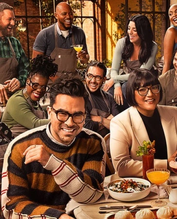 Group of diverse chefs and culinary hosts smiling around a restaurant table with drinks and dishes by Art Streiber