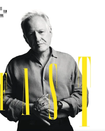 Promotional portrait of an adult male with silver hair, wearing a gray button-down shirt. Text is partially visible over the image.