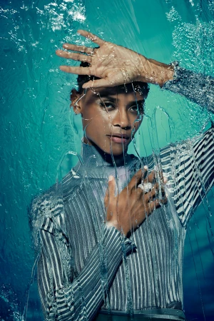 Portrait of a woman wearing a striped top behind a layer of splashing water by photographer Art Streiber