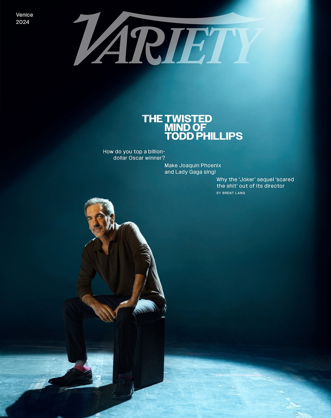 Variety magazine cover featuring Todd Phillips seated on a black block under a spotlight in a dark studio, Venice 2024 issue.