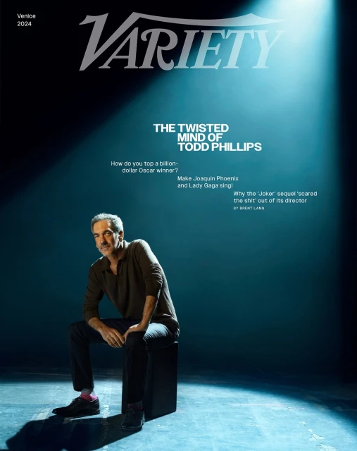 Variety magazine cover featuring Todd Phillips seated on a black block under a spotlight in a dark studio, Venice 2024 issue.