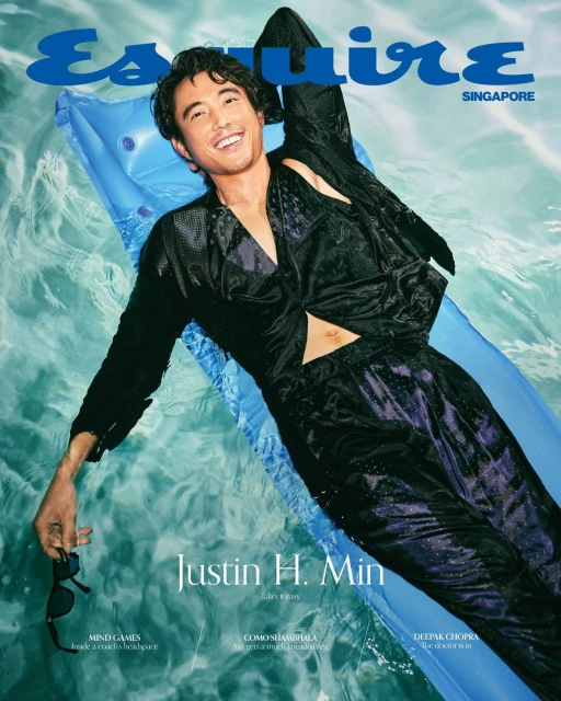 Esquire Singapore magazine cover features Justin H. Min lying on an inflatable raft in a pool, wearing a black patterned outfit and sunglasses.