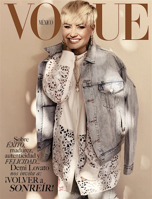 Demi Lovato on the cover of Vogue Mexico wearing a denim jacket and white shirt with cutout details, set against a neutral backdrop.