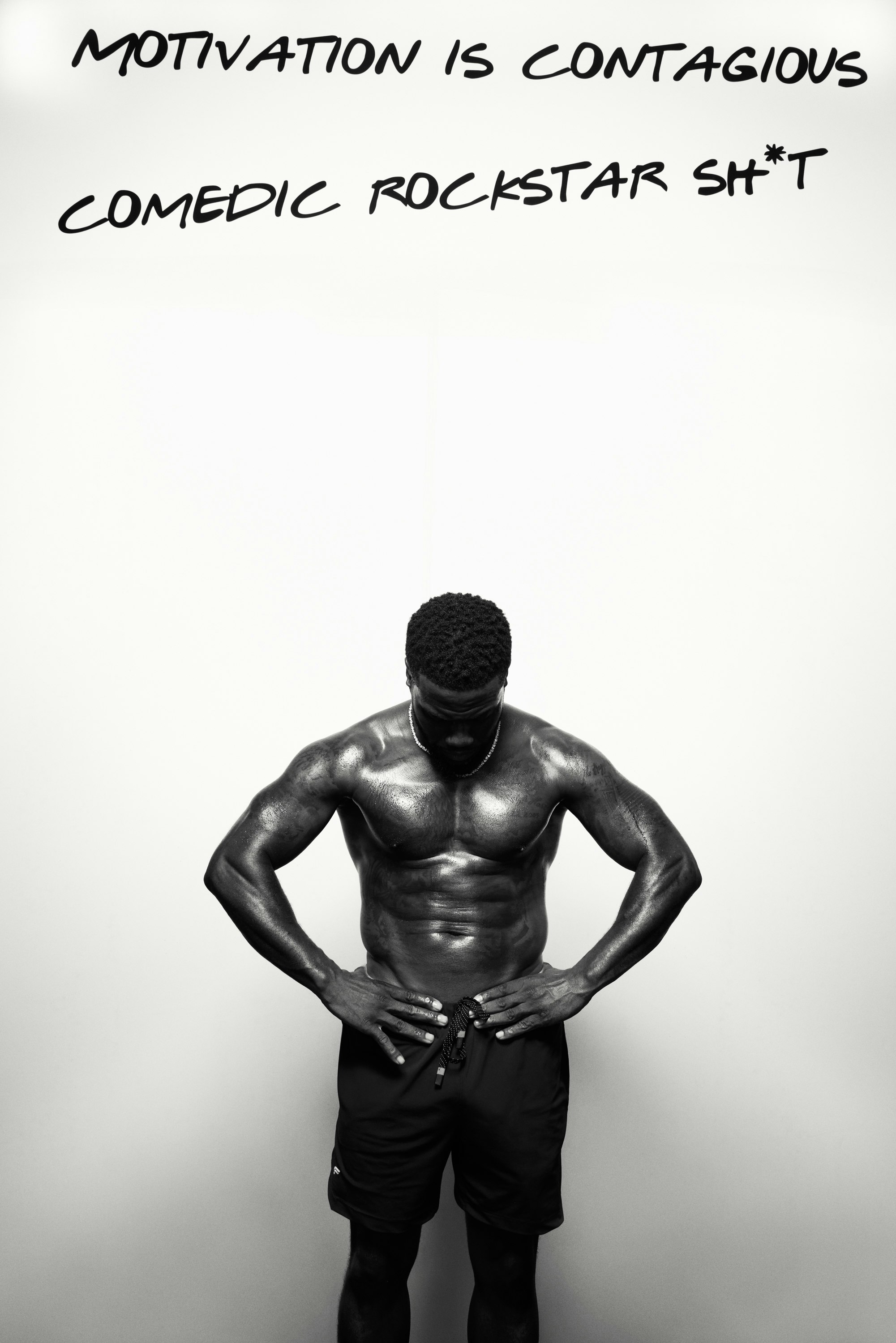 Athletic Black man poses shirtless indoors against white background with motivational text; shoulders and chest are emphasized by lighting.