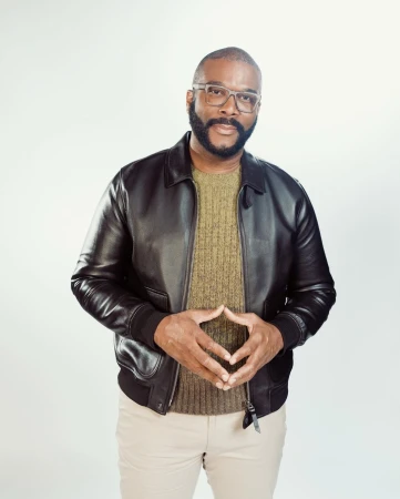Portrait of Tyler Perry wearing a black leather jacket and glasses against a white background by photographer Braylen Dion