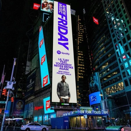 Nighttime billboard in Times Square advertises new music from Lil Tjay featuring YoungBoy Never Broke Again and Spotify's New Music Friday playlist.