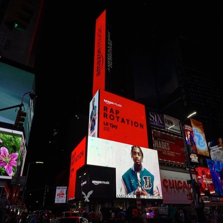 Times Square billboards at night with Amazon Music ads including Lil Tjay and American Eagle Outfitters with illuminated signs.