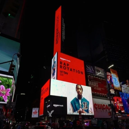 Times Square billboards at night with Amazon Music ads including Lil Tjay and American Eagle Outfitters with illuminated signs.