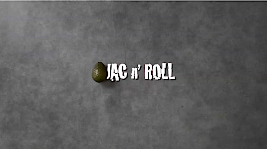 Overhead shot of an avocado and the text 'Jac N' Roll' on a textured gray surface creating a simple food-themed image.