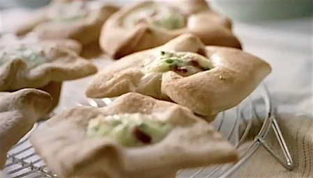 Savory star-shaped pastries with creamy filling on a wire rack. Food photography showcasing baked goods with golden crust and savory ingredients.