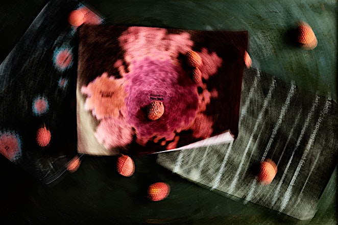 Artistic still life with lychee fruits scattered around, displayed on vintage newspapers and a dark green surface with motion blur.