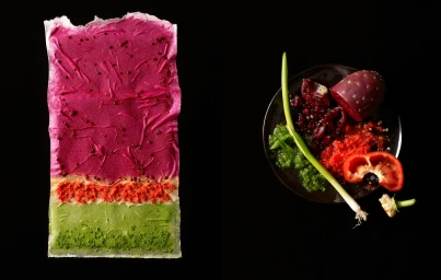 Textured magenta and green pressed food sheet beside a black plate with fresh produce, shot by Beth Galton.